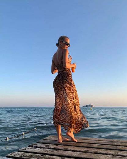 A woman in a leopard print dress standing on a dock.