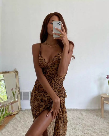 A woman in a leopard print dress taking a selfie.