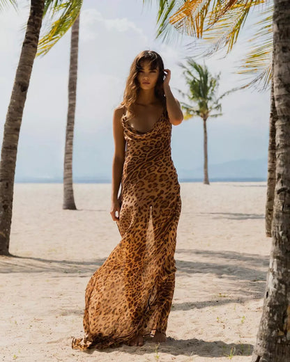 A woman in a leopard print dress standing on a beach