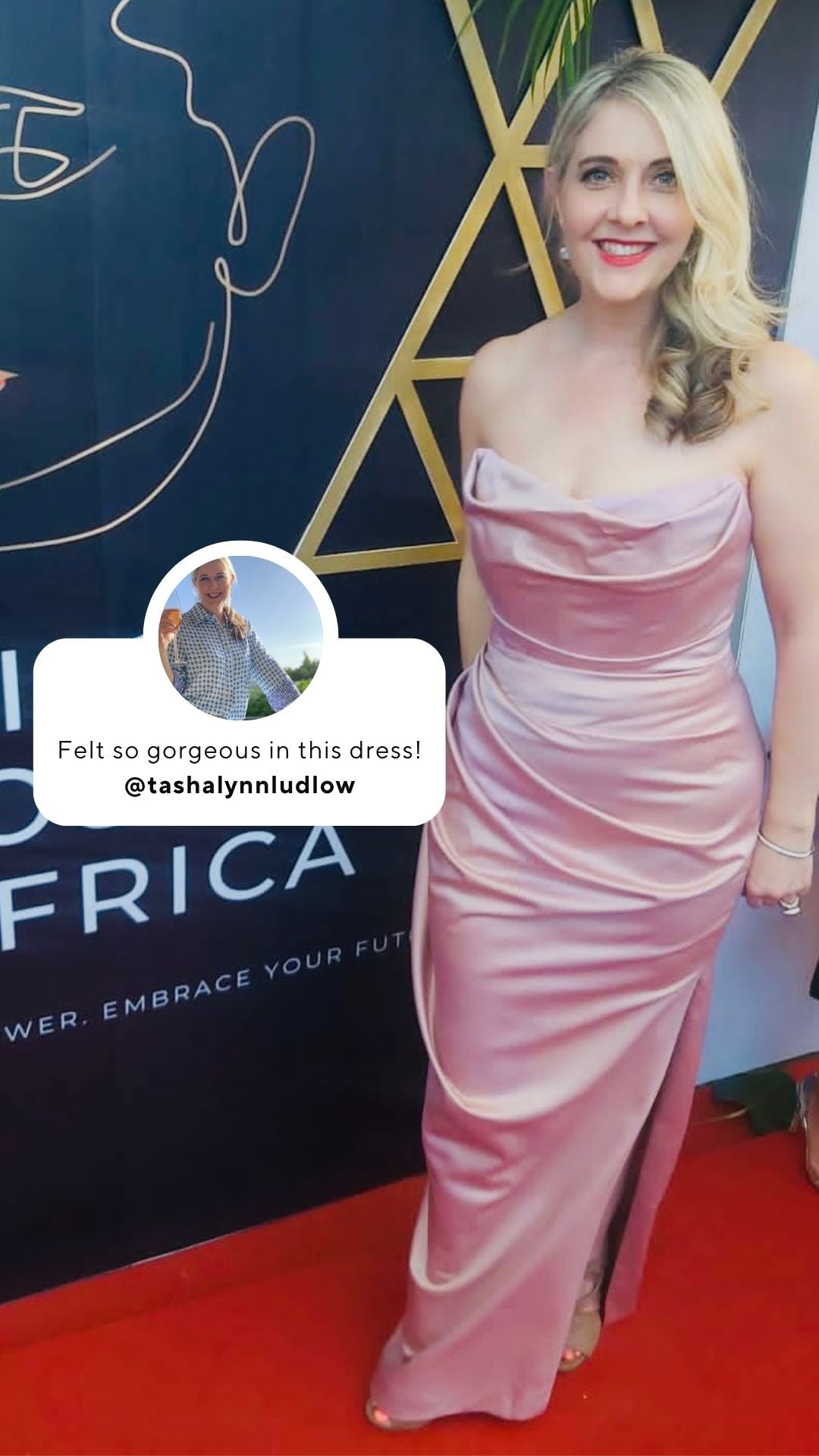 A woman in a pink dress standing on a red carpet.