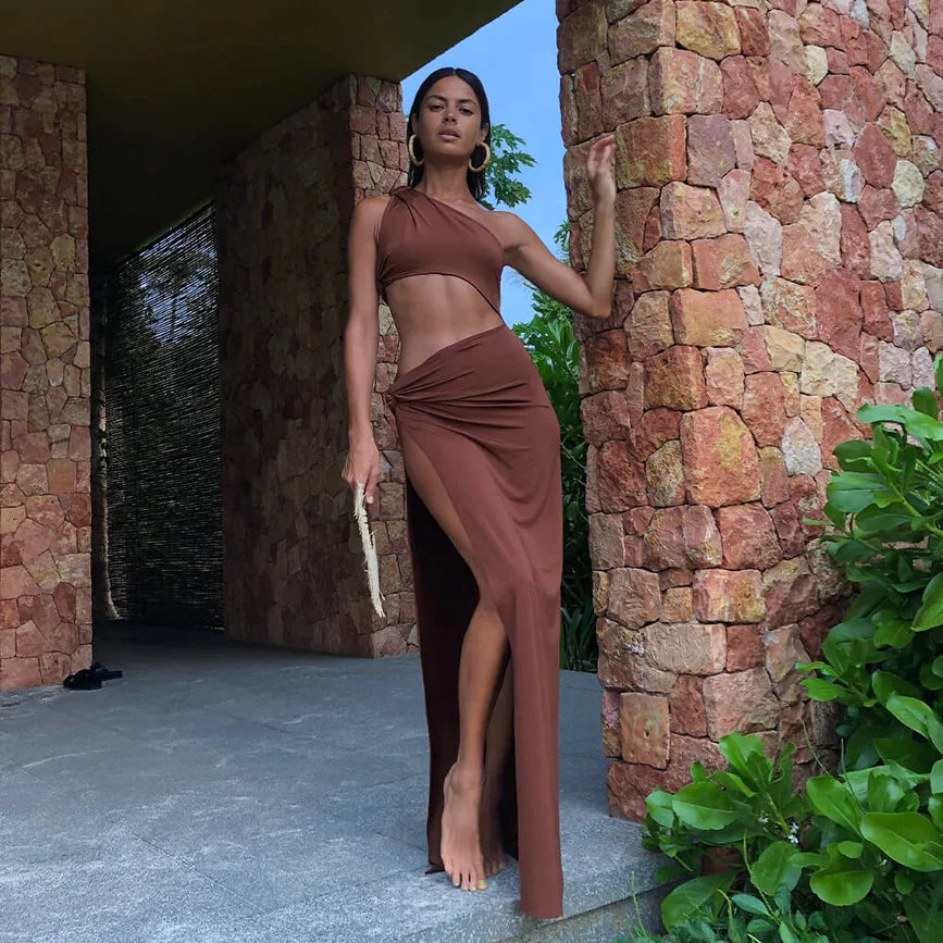 A woman in a brown dress posing in front of a building.