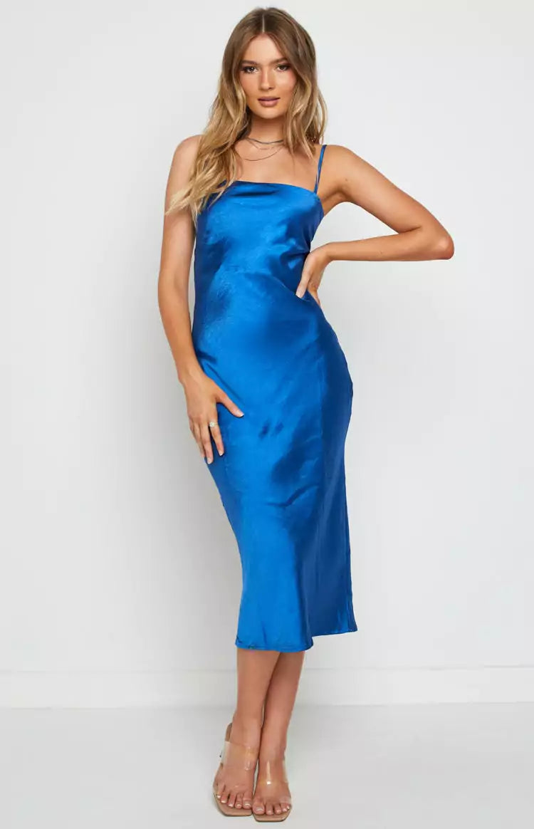 The model is wearing a blue satin slip dress.