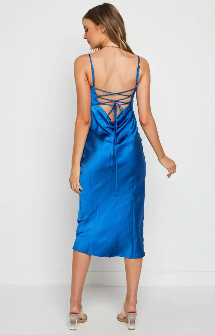 The back view of a woman wearing a blue satin slip dress.