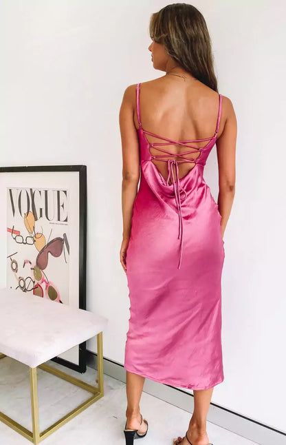 The back view of a woman wearing a pink satin slip dress.