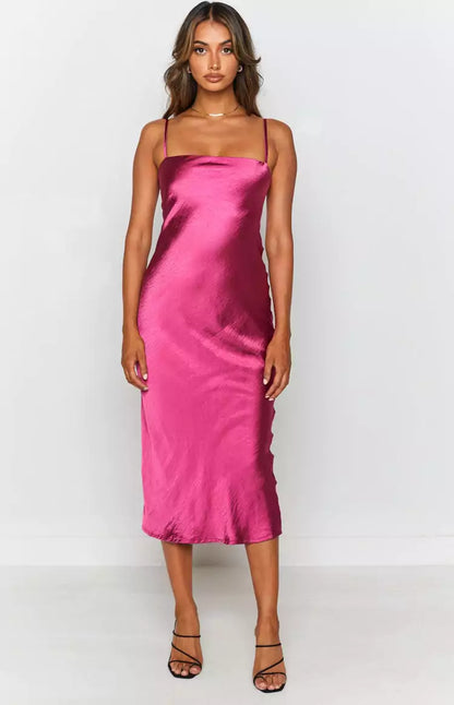 Makenna Wine Midi Dress - A woman wearing a fuchsia satin slip dress, perfect for a bridal party or as bridesmaid dresses.