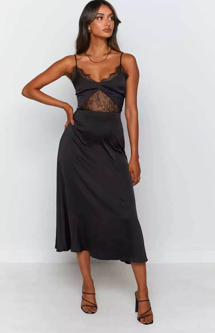 The model is wearing a black slip dress with lace detailing.