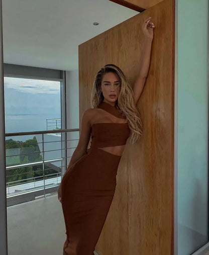 A woman in a brown dress posing in front of a door.