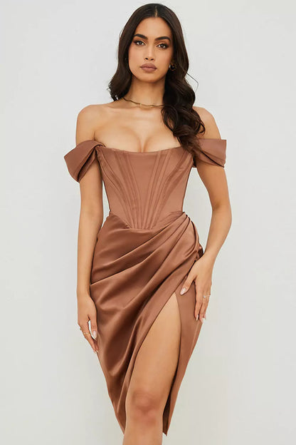 The model is wearing a brown satin dress with a slit.