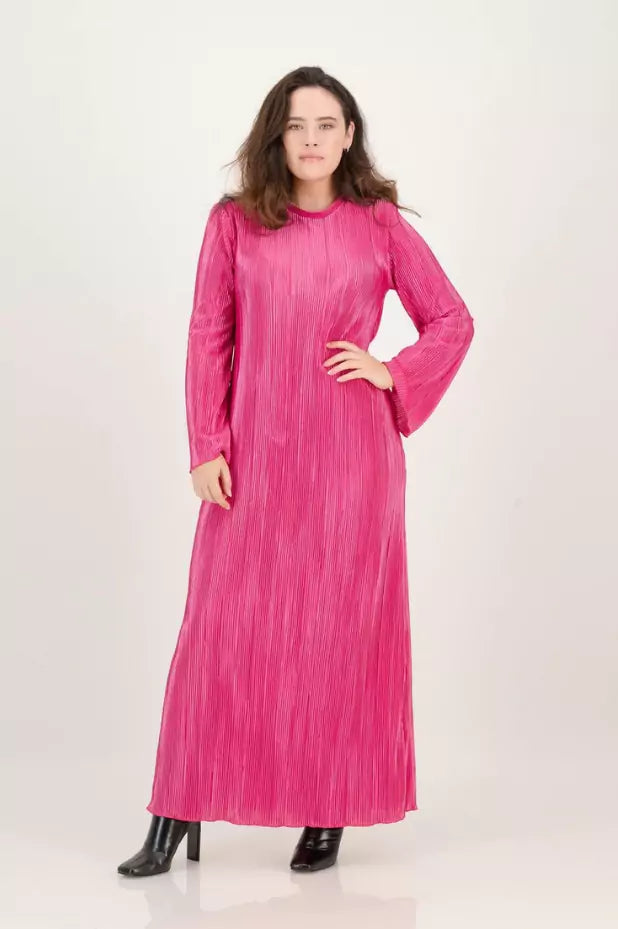 A woman is posing in a pink long sleeved dress.