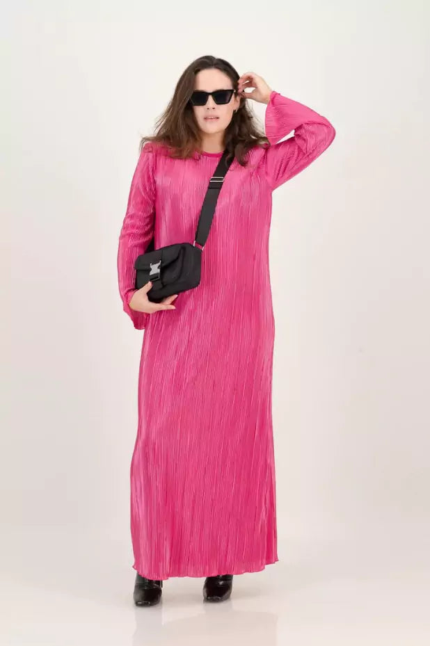 A woman wearing a pink maxi dress and sunglasses