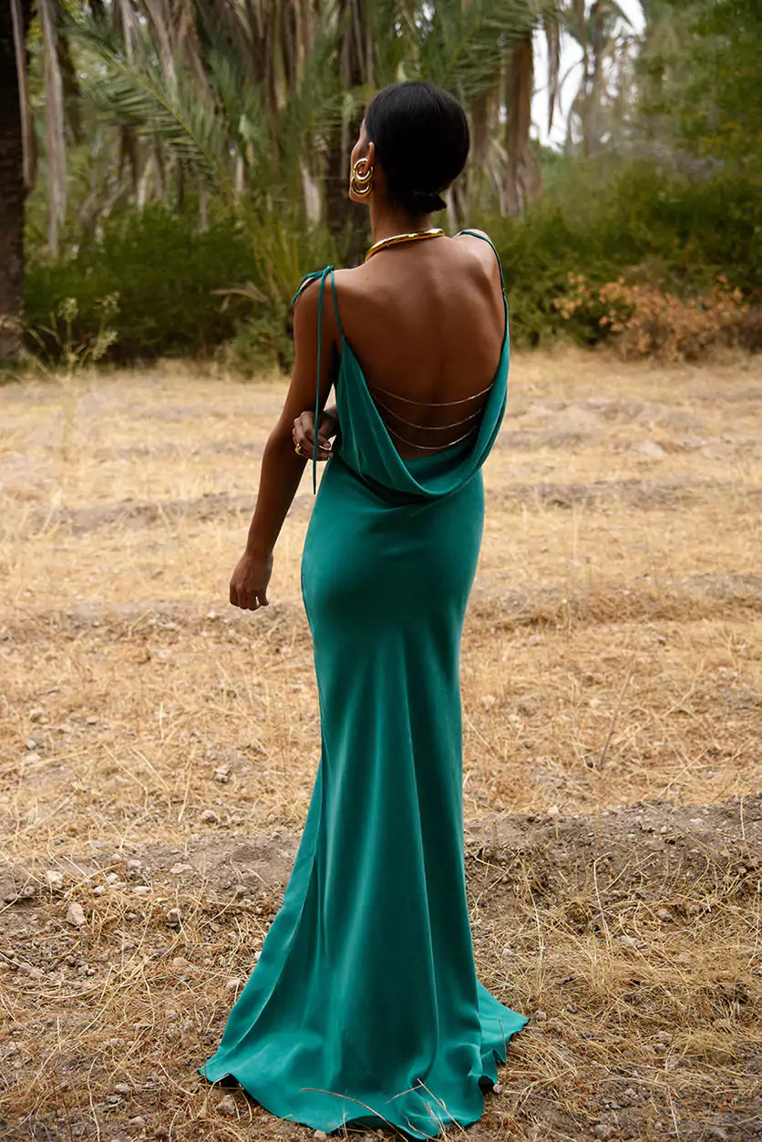 A woman in a green dress standing in a field.