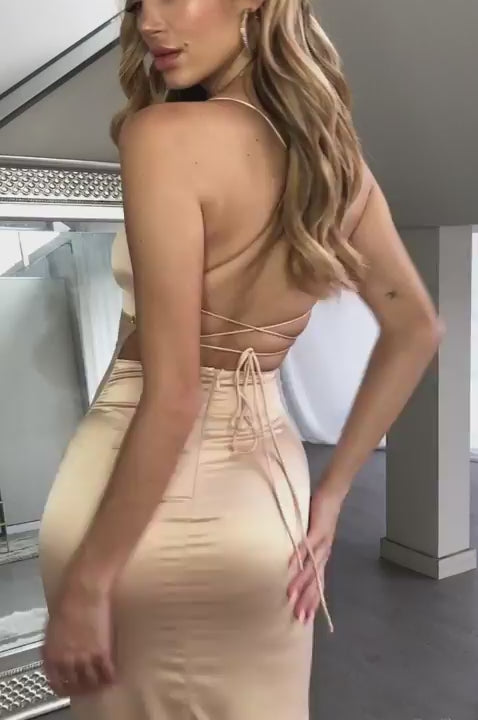 The model is wearing a beige satin maxi dress.updated#gid://shopify/Video/22675993493574#video_id