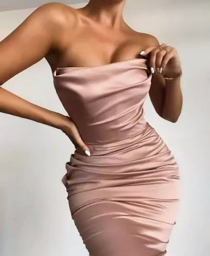 A woman is posing in a pink satin dress.
