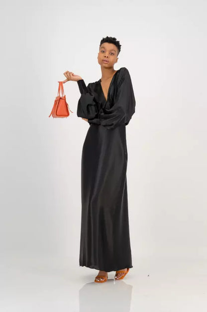A woman in a black dress holding a red bag.
