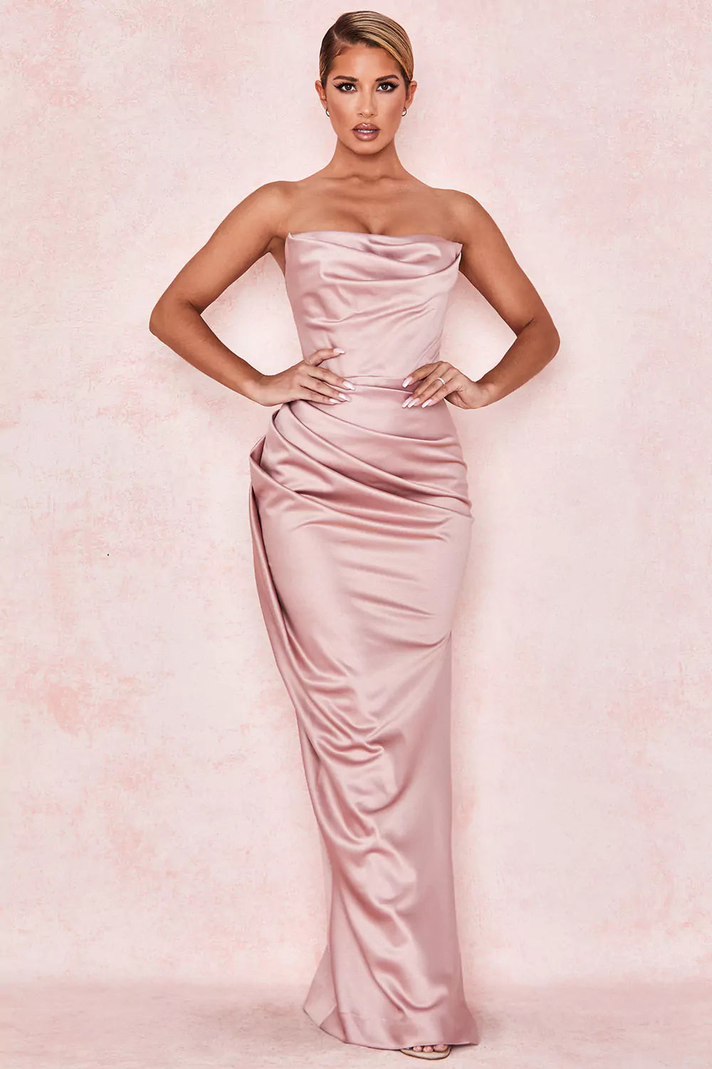The model is wearing a pink strapless maxi dress.
