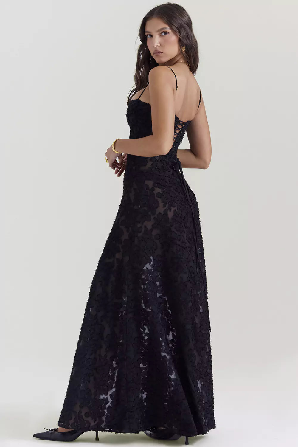 The back view of a woman wearing a black lace dress.