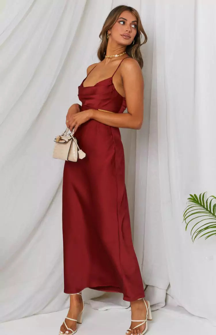 The model is wearing a burgundy satin slip dress.