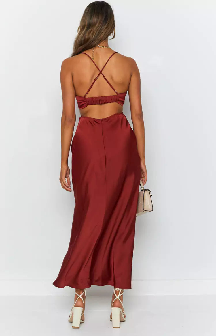 The back view of a woman wearing a burgundy satin maxi dress.