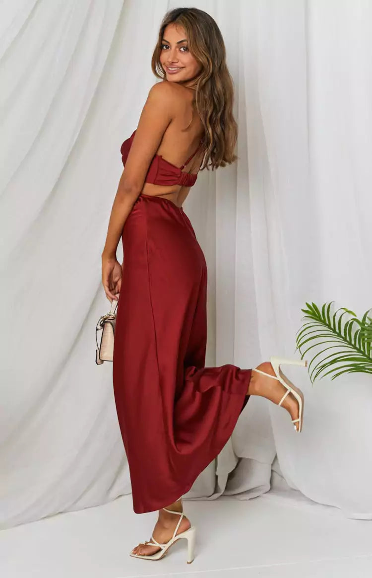 The model is wearing a burgundy satin dress.