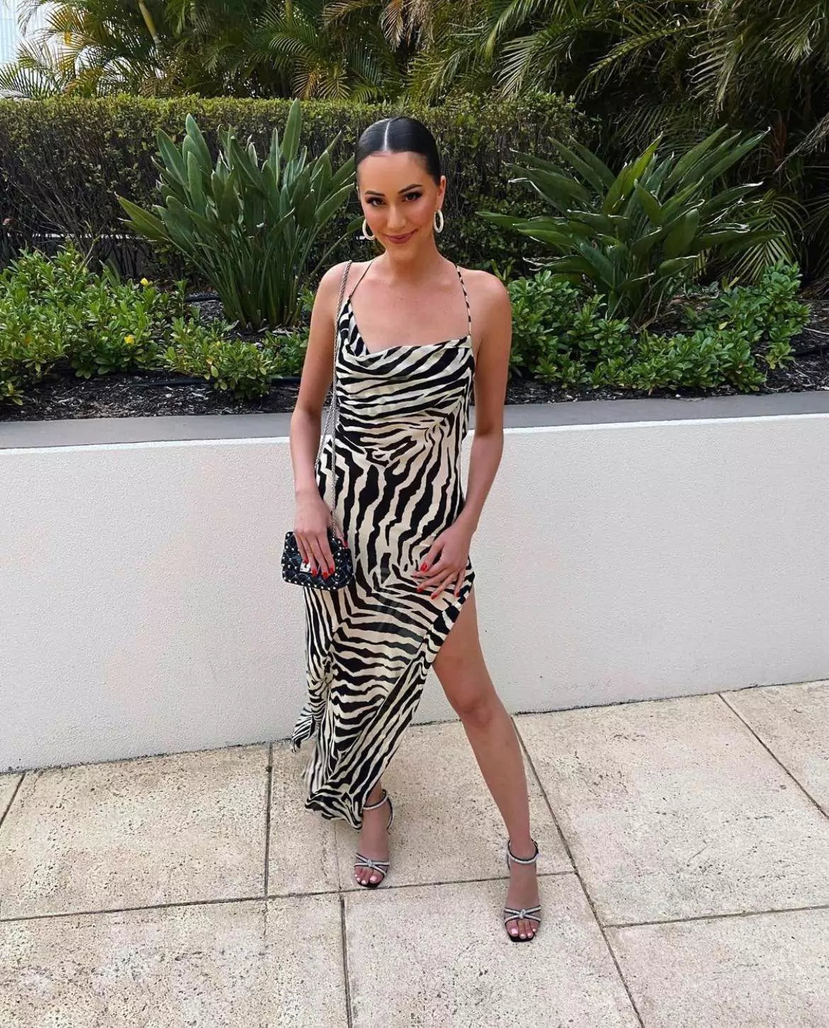 A woman posing in a zebra print dress.