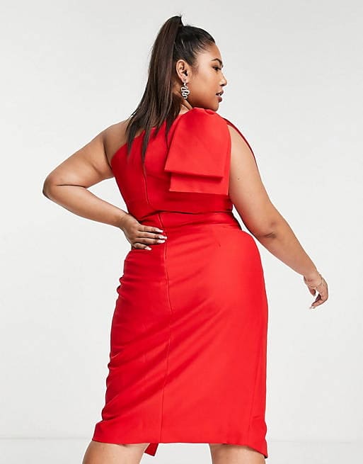 A plus size woman wearing a red one shoulder midi dress.