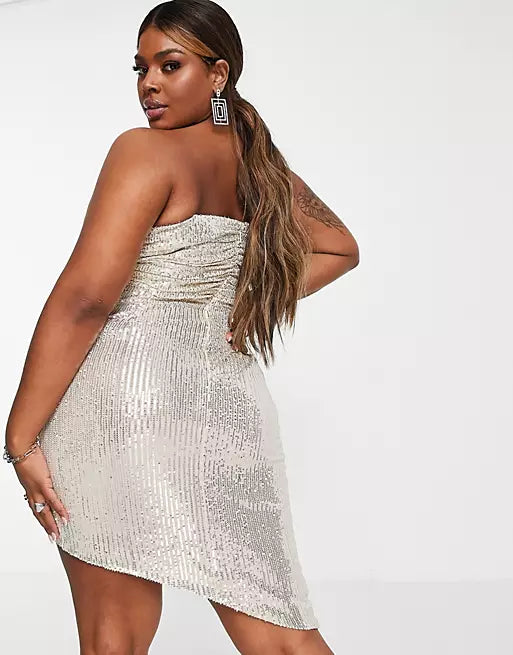 A plus size woman wearing a silver sequin dress.