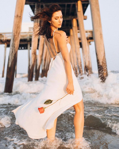 A woman in a Callista White Plus Size Cocktail Dress standing under a pier.