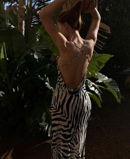 A woman in a zebra print dress standing in a garden.