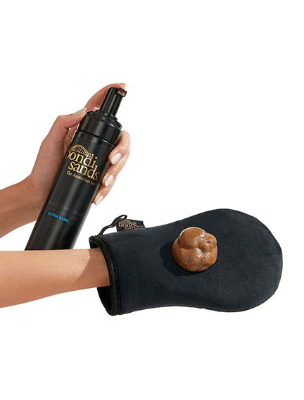 A woman is holding a black glove with a poop on it.