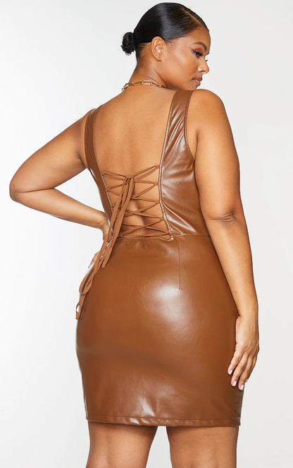 The back view of a woman in a brown leather dress.