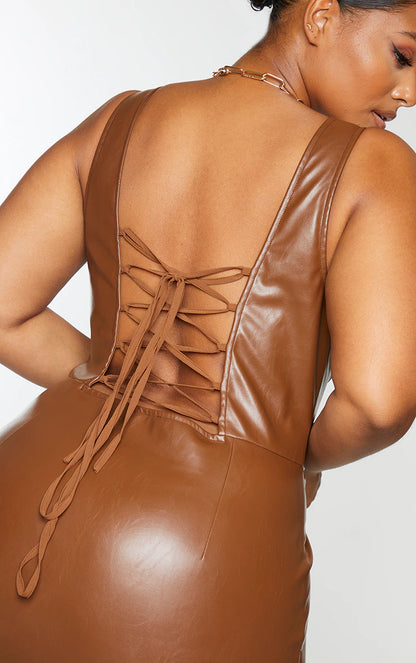 The back view of a woman in a brown leather dress.